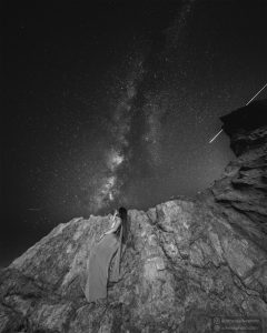 Nightscape φωτογράφιση Milky Way με μοντέλο πάνω στα βράχια